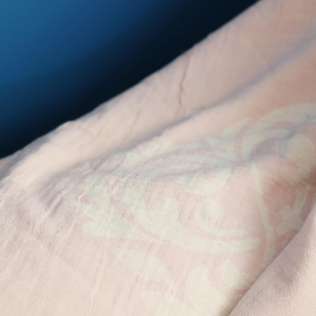 Soft, powder-pink color Turkish peshtemal blanket on a sofa