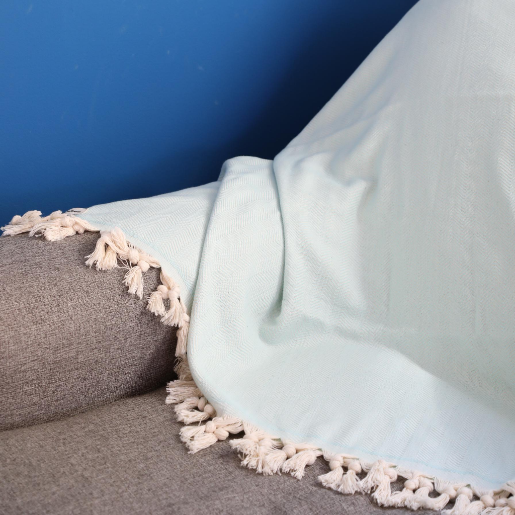 Turquoise color, cotton Turkish beach-picnic blanket on a sofa