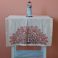 hand-made table runner decorated with red, floral designs 