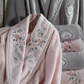 Powder-pink,  women`s bathrobe and bath towel decorated with pink and grey floral designs