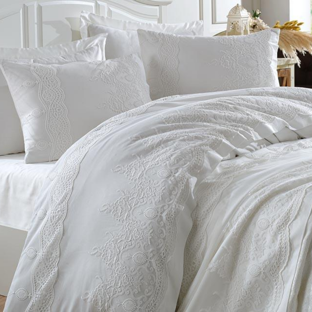 Bride`s bedroom decorated with pure white bedding set ornamented with lace all over the bedspread and duvet cover