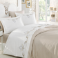 Modern, white bedroom decorated with bed linen in beige and white colors