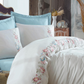 Classic bedroom is refreshed with white duvet cover and blue bed sheet, pillows