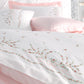 White duvet cover and shams decorated with delicate, pink and green floral embroideries
