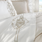 Cotton-sateen, white duvet cover and shams are ornamented with golden bronze, damask pattern embroideries