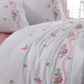 Pink and green flower and butterfly designs on white duvet cover pairs with pink bed sheet