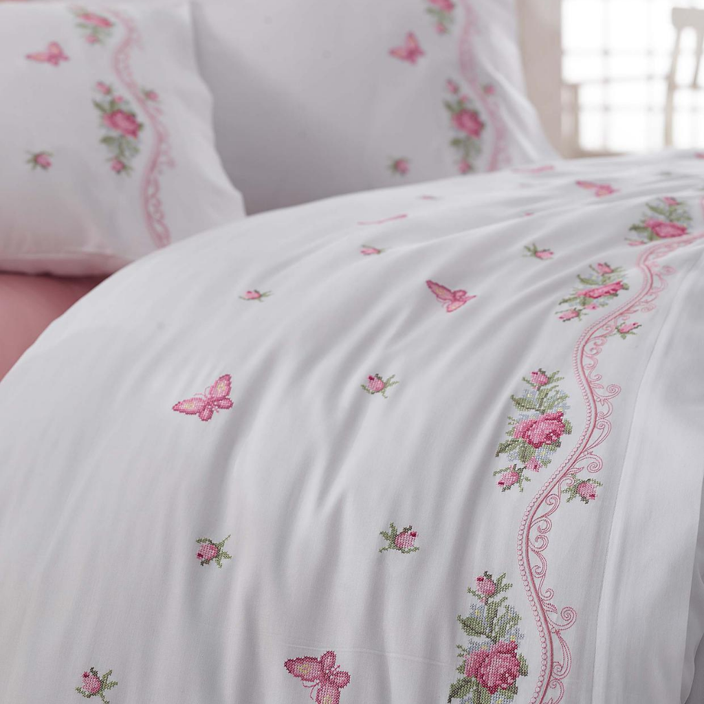 Pink and green flower and butterfly designs on white duvet cover pairs with pink bed sheet