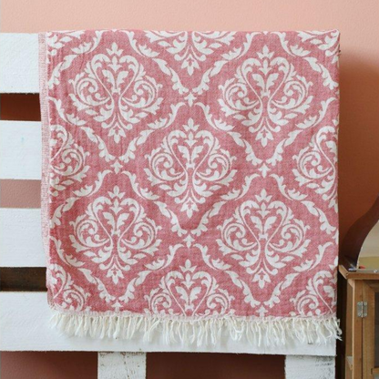Red Oriental Turkish peshtemal towel hanging on the bed frame