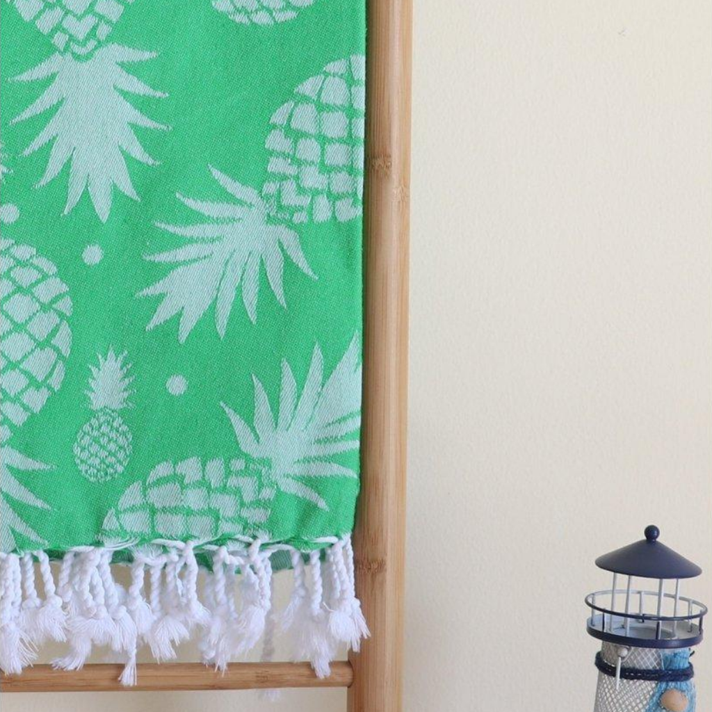 Green, absorbant Turkish towel has pineapple designs