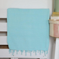 Turquoise, stone-washed Turkish towel on a bed frame