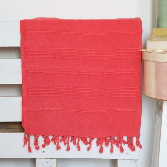 Vermilion-red color Turkish beach/bath towel on a bed frame