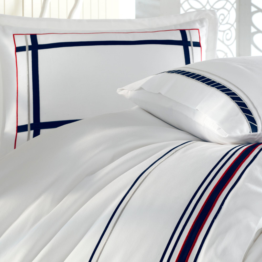 White, cotton-sateen duvet cover and pillows embroidered with red and navy lines