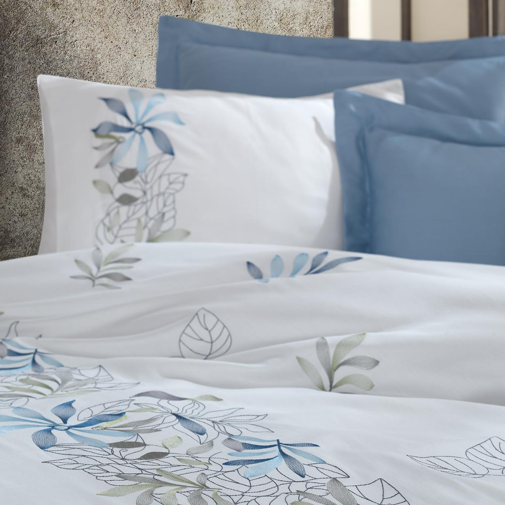 Blue and grey floral and leaf designs make a combination with blue bed sheet and pillows